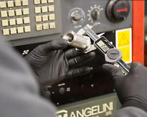 Techniker prüft Messgerät mit Digitalmultimeter in der Werkstatt.